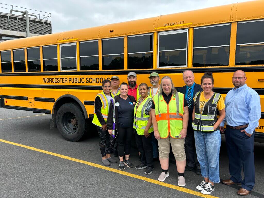 Members of the WPS Transportation Department in front of a school bus.