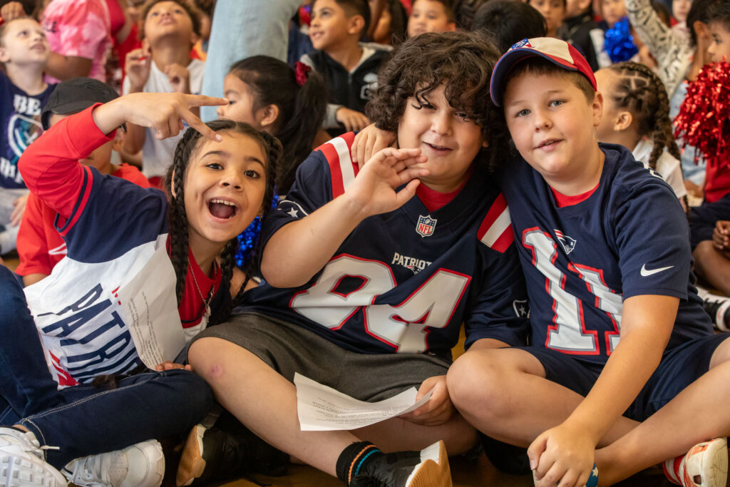 Children wave while wearing Patriots shirts