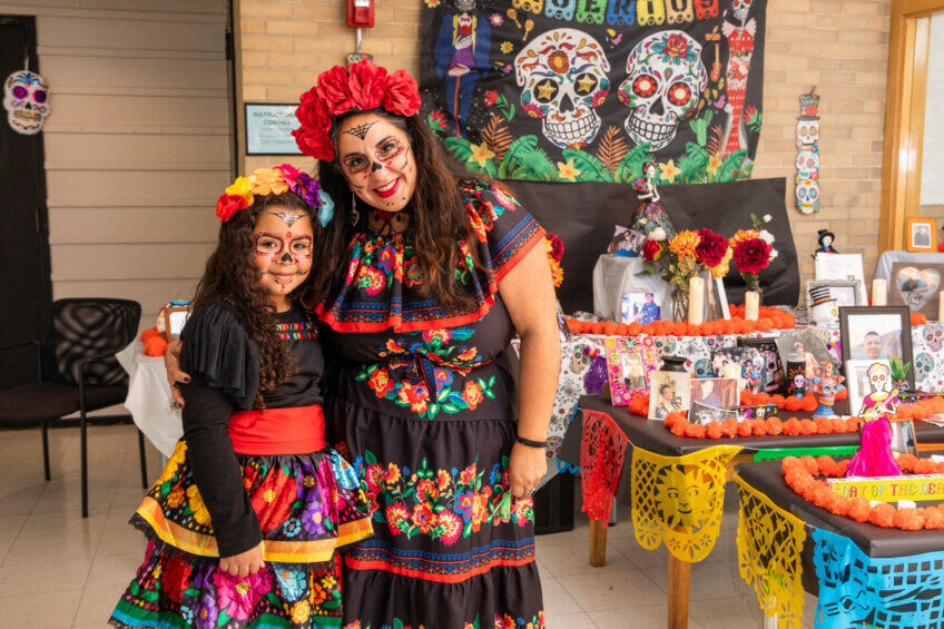 The principal and a student dressed in Dia de los Muertos attire.